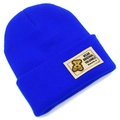 Détail d'un bonnet en maille bleu vif avec écusson d'ours et broderie décorative - Bleu royal