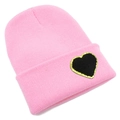Detail shot of the pink knit beanie featuring a black heart patch with gold glitter edges - One Size / Pink