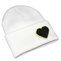 Detail view of a white knitted beanie featuring a black heart patch with gold sequin edges - One Size / White