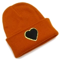Detail of orange knit beanie featuring a black heart patch with gold sequin embroidery - Caramel color