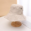 Primo piano dettaglio del cappello bucket beige effetto vissuto a tesa larga sul supporto. - Plaid Beige