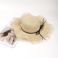Detalle de sombrero de paja con ala ondulada, lazo negro y tejido aireado con rayas - Caqui