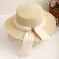 Cappello di paglia a cima piatta con fiocco su cesto bianco per spiaggia e moda estiva - Beige