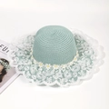 Mint green straw sun hat with white lace brim and daisy flower decorations in a top view - One Size / Green