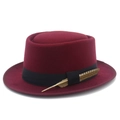 Détail d'un chapeau Pork Pie bordeaux avec ruban noir et accent de plume brune - Taille unique / Bordeaux