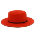 Detailed macro view of bright red straw boater hat with black studded leather belt - Red