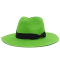 Detail of bright green woven straw hat featuring a black ribbon bow and natural texture - Verdant
