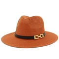Dettaglio cappello di paglia arancione con fascia nera e fibbia decorativa in metallo dorato - Caramello