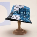 Gros plan d'un bob en patchwork avec motifs paisley et floraux sur support en bois - Taille unique / Feuille Paisley Bleu Blanc Noir