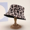 Close-up of leopard print bucket hat on a wooden stand with elegant canvas texture - Classic Brown Black Leopard Canvas (37)
