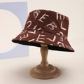 Minimalist brown canvas bucket hat with white graffiti text on a wooden display stand - Brown Base White Letter Graffiti (73)