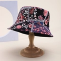 Detail shot of a black bohemian bucket hat with vibrant floral patterns on a wooden stand - Black Base Colorful Bohemian Floral (69)