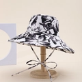 Detail view of wide brim sun hat with bold black and white floral pattern and chin straps - Black And White Floral Style (1#)