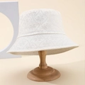 Elegant ivory bucket hat with floral lace embroidery on wooden stand for outdoor fashion - White