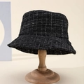 Classic black and white checkered tweed bucket hat displayed on a wooden stand - Black