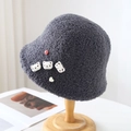 Dark grey fleece bucket hat with cute bear patches on a wooden stand for winter warmth - One Size / Gray
