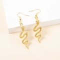Detailed macro view of golden snake-shaped alloy earrings with textured scales - Gold