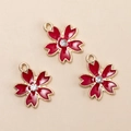 Three deep red cherry blossom alloy pendants with rhinestones on a beige background - Red Flower