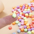 Perles alphabet coeur macaron 7mm pour bracelets DIY posées sur le doigt - Style de lettre / Pack de 100 / Couleurs Mélangées Macaron