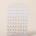 Set van minimalistische gouden bolvormige oorknopjes in diverse maten op witte kaart - Grote Gouden Ronde Bal Set Stijl