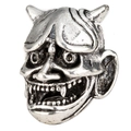 Macro shot of a vintage silver Viking bead featuring a detailed demon mask design - Prajna Mask Style