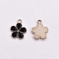 Macro detail of enamel flower pendants showing the black finish and golden metal backing - Round Edge Five Petal Flower / Black