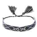 Dettaglio di un braccialetto dell'amicizia intrecciato a mano con ricamo LOVE e nappe nere e bianche - Quadri Nero e Bianco (Love)