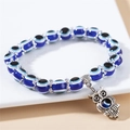 Detailansicht der blauen Evil-Eye-Perlen und des Vintage-Silber-Eulenanhängers am Armband - Blaue Eule Lila