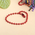 Detail of red painted metal bead chain with connector clasp against a colorful background - Red