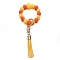 Dettaglio di perle in silicone gialle e arancioni con nappina e chiusura in metallo dorato - Stile Giallo Arancio