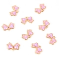 Close-up of nine light purple bow pendants with gold edges for jewelry making - Bow Tie / Purple