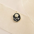 Makroaufnahme einer vergoldeten Rosen-Anhänger mit LOVE-Gravur auf weichem Satinband - Schwarze Unregelmäßige Ovale Rose (LOVE)