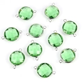 Flat lay of faceted emerald green glass charms with silver metal frames for DIY jewelry - Green