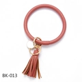 Nahaufnahme von rosa PU-Leder Armband Schlüsselanhänger mit Goldring und Quasten-Detail - Erdrot (BK-013)