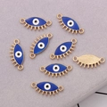 Detalle de dijes de ojo turco azul con bordes dorados y pestañas para crear bisutería - Conector Ojo Turco Azul (Base Dorada)