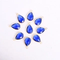 Makro-Detail von facettierten dunkelblauen Glastropfen mit Goldrahmen für DIY-Schmuck - Tropfenform / Goldbasis Blaues Kristallglas
