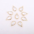 Macro view of faceted teardrop glass crystal charms with gold-plated metal borders - Teardrop / Gold Base Transparent Crystal Glass