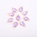 Detailed macro view of eight faceted purple crystal teardrop pendants with gold metal frames - Teardrop / Gold Base Purple Crystal Glass