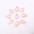 Close-up of pink faceted teardrop glass pendants with gold-plated metal edges and bails - Teardrop / Gold Base Pink Crystal Glass