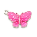 Makroaufnahme von rosa Glitzer-Schmetterlingsanhänger mit Silberrahmen für DIY-Schmuck - Rosa