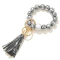 Macro view of floral lace pattern wooden beads with snakeskin print tassel and gold ring - Black with Silver Back