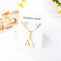 Detailed macro view of gold-plated stainless steel tropical fish necklace and earrings set - Tropical Fish Style