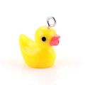 Macro shot of bright yellow resin duck pendant with silver metal ring for DIY jewelry - Yellow