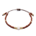 Detail van een handgemaakte kralenarmband met bruine kralen en een zoetwaterparel - koffiekleur
