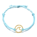 Detail van lichtblauwe gevlochten armband met een gouden golfbedel op witte achtergrond - Lichtblauw