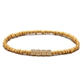 Detail van gouden kralenarmband met vier gepolijste metalen vierkanten op een witte basis - Goud
