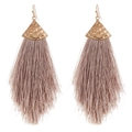 Detail von gehämmertem Goldpfeil-Metallsockel und lila Quaste an Boho-Ohrringen - Beige
