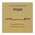 Detailopname van een handgemaakte gouden Morsecode armband met de tekst Hope op kaart. - HOPE