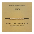 Detail of handmade Morse code bracelet with gold beads on a Luck message card - Luck