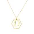 Macro-opname van de gepolijste vergulde zeshoekige hanger met artistieke letter D-gravure - Letter D